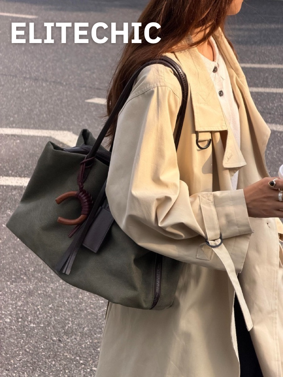 Cô gái mặc trench coat đeo túi tote canvas xanh rêu