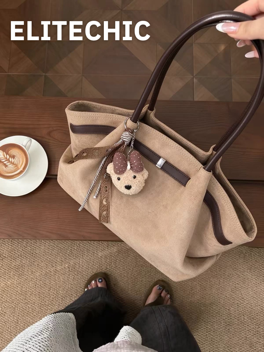 Tay cầm túi tote da lộn kem bên bàn cà phê