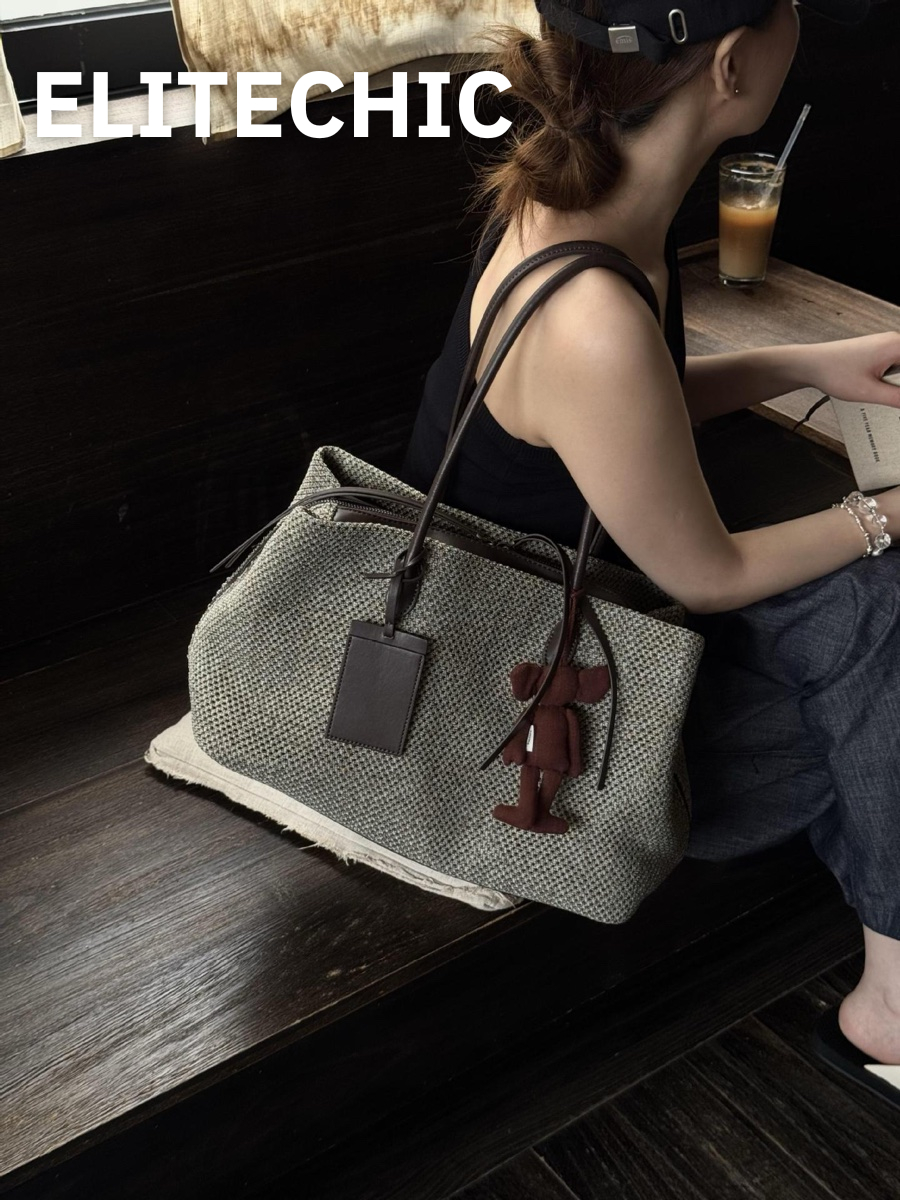 Túi tote đan đặt cạnh cô gái ngồi ở quán cà phê